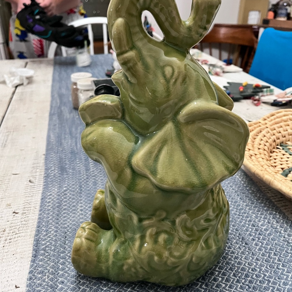 Elephant ceramic- Green Glaze Sitting with Floral Relief Design 10 1/2” euc